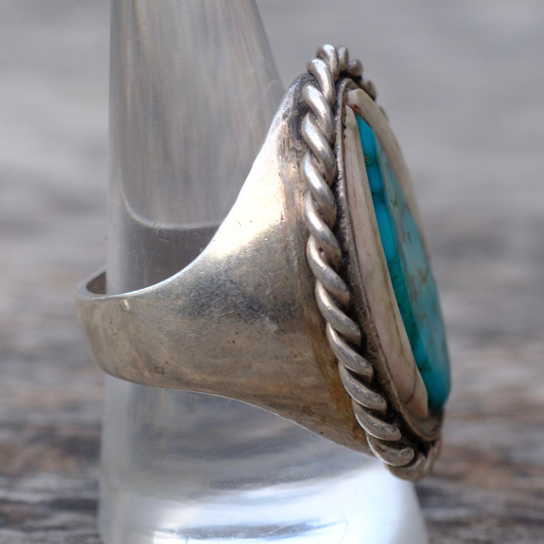 Silver ring with turquoise stone on a blurred background