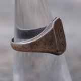 Bronze ring with a textured surface on a metallic stand