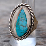 Silver ring with a turquoise stone on a wooden surface