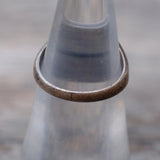 Close-up of a metal ring on a glass bottle with a blurred background