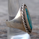 Silver ring with turquoise stone on a blurred background
