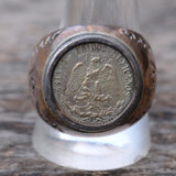 Close-up of a Mexican Peso Ring embedded in a wooden block