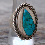 Silver ring with turquoise stone on a wooden surface