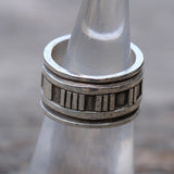 Close-up of a silver ring on a metallic surface with a blurred background