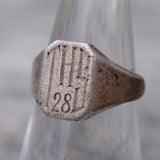Silver ring with engraved design and number '28' on a metallic background