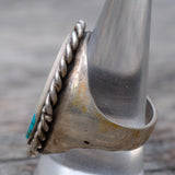 Close-up of a silver ring with turquoise stone on a wooden surface