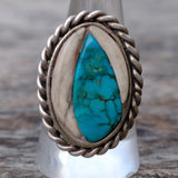 Silver ring with turquoise stone on a wooden background